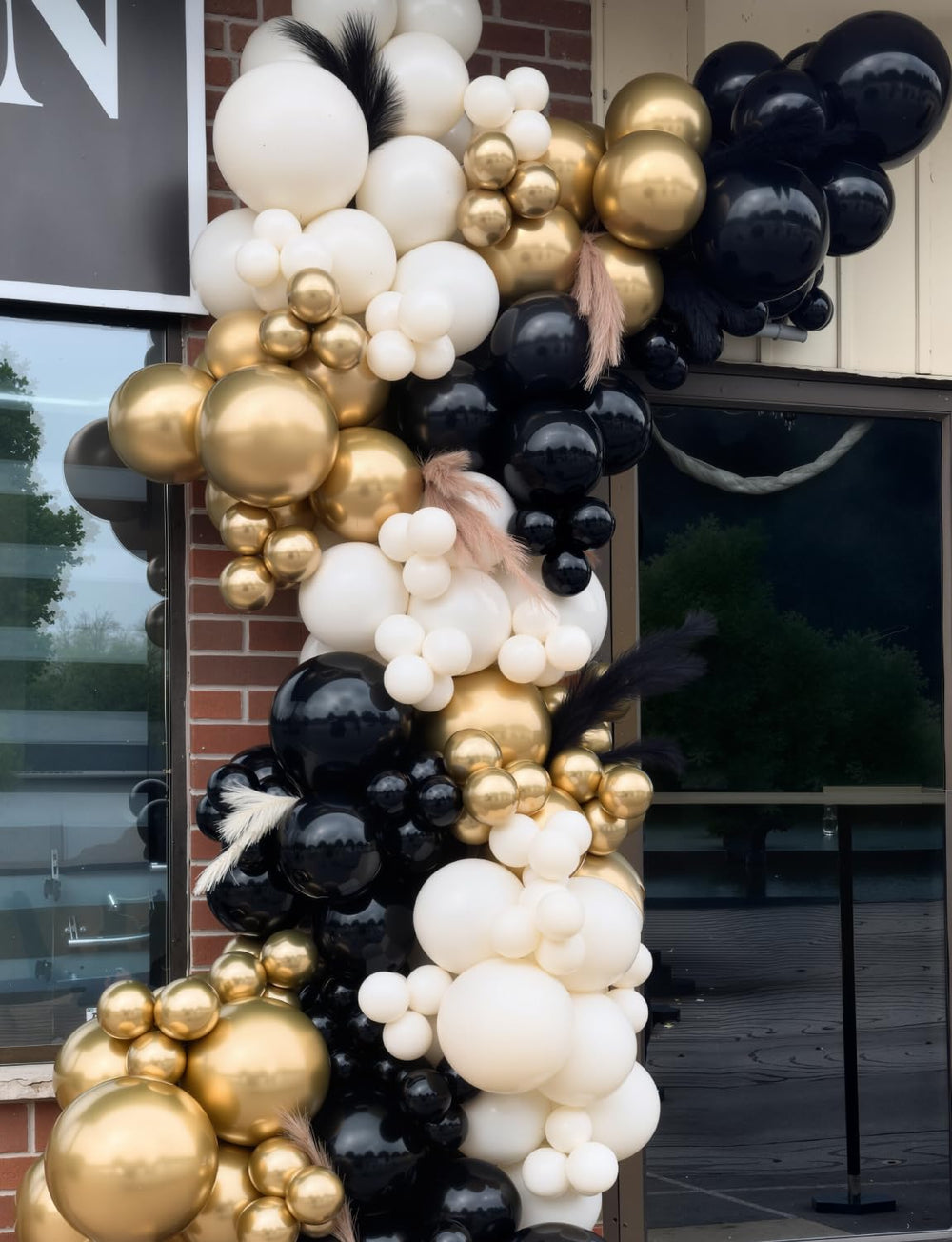 Glue dots and white ribbon help secure the balloon arch.