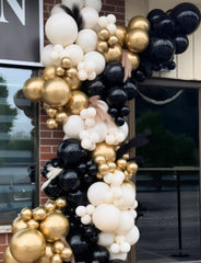 Glue dots and white ribbon help secure the balloon arch.