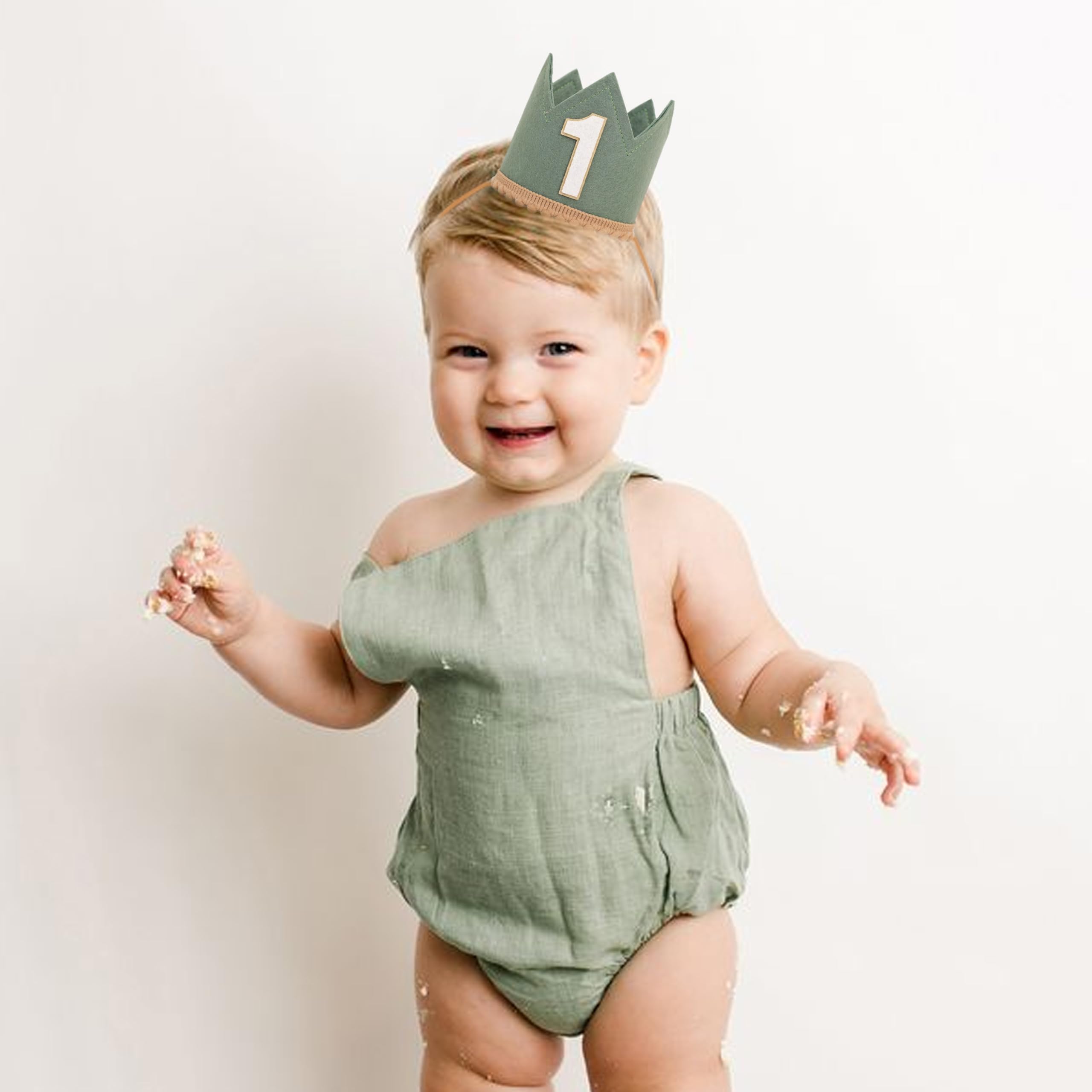 Baby wearing Agvgaza crown during jungle-themed cake smash for memorable photos.