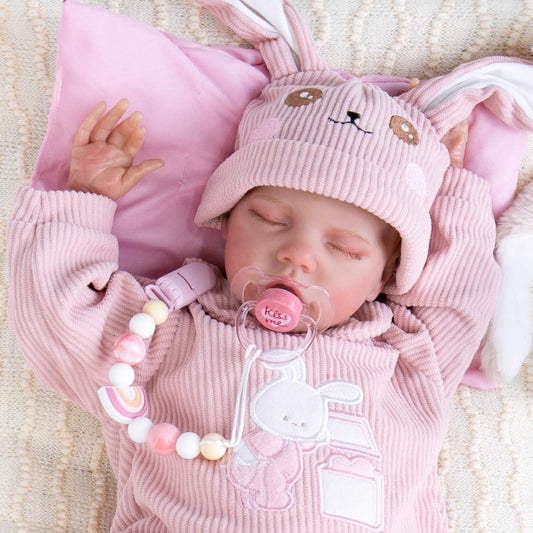 Closeup of pink magnet pacifier clip showing strong grip on doll clothing