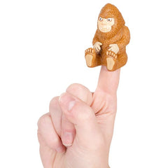 Archie McPhee Bigfoot finger puppet seated on a finger, great for playful storytelling.