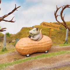 Archie McPhee possum in a peanut pull-back toy car close-up vinyl texture detail.
