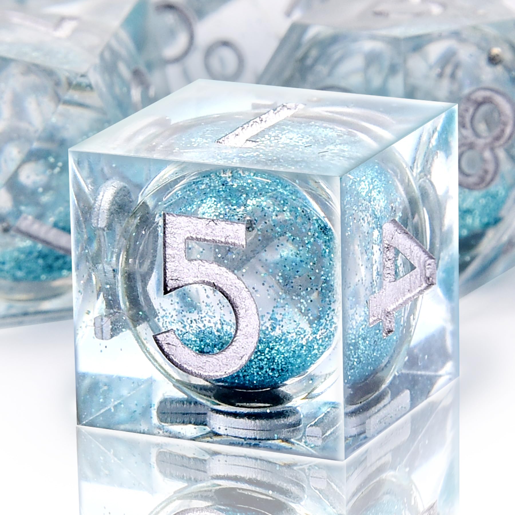AUSTOR resin dice close-up showing mirrored finish and gemstone-like edges.