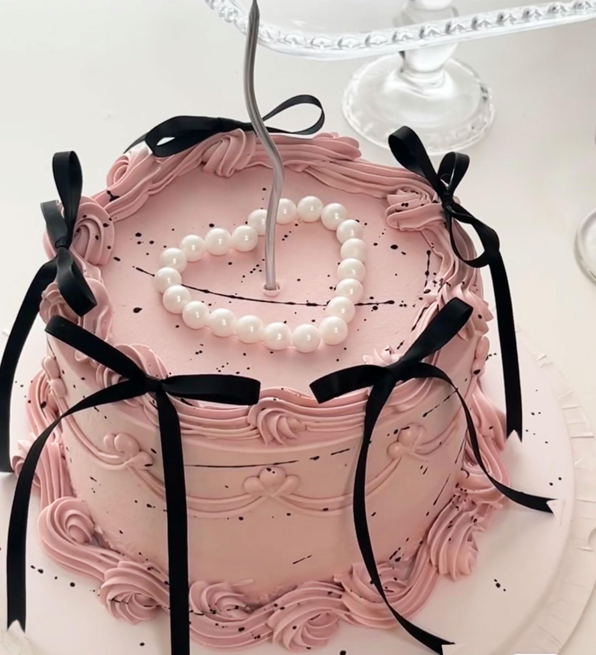 Bach and Boujee black bow cake topper on a white cake, romantic centerpiece.