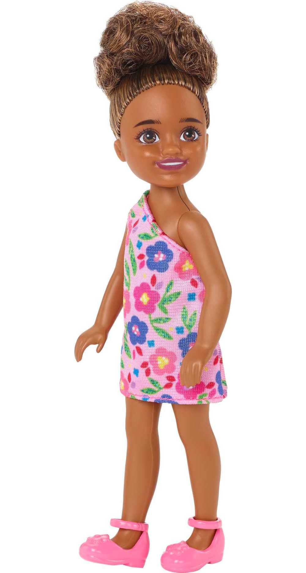 Barbie Chelsea doll in brunette curls wearing a one-shoulder flower-print dress for imaginative play.