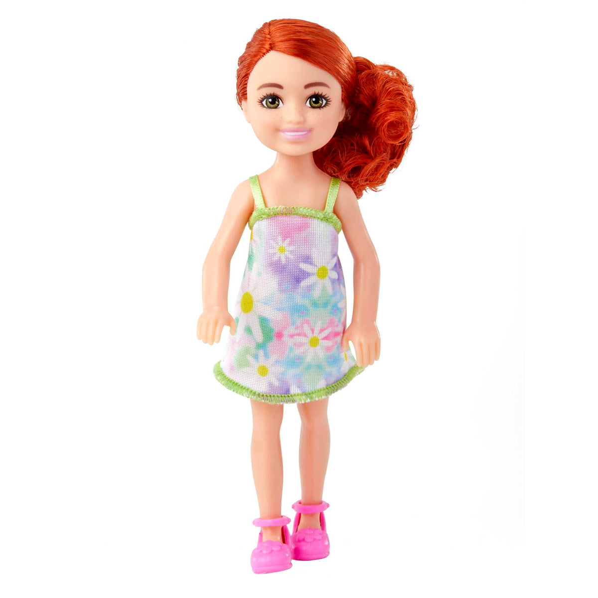 Barbie Chelsea doll in romper and white sneakers with brunette hair and brown eyes for imaginative play.