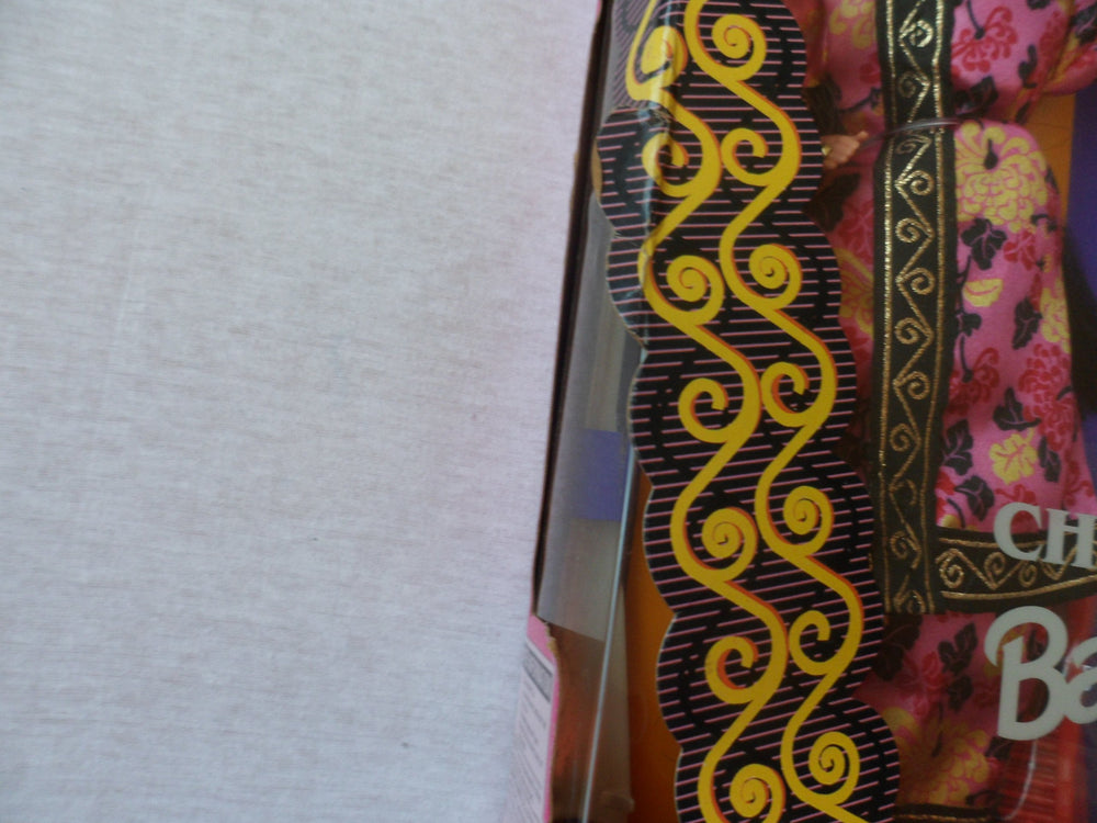 Barbie in chrysanthemum print guazi robe close-up highlighting vibrant pattern.