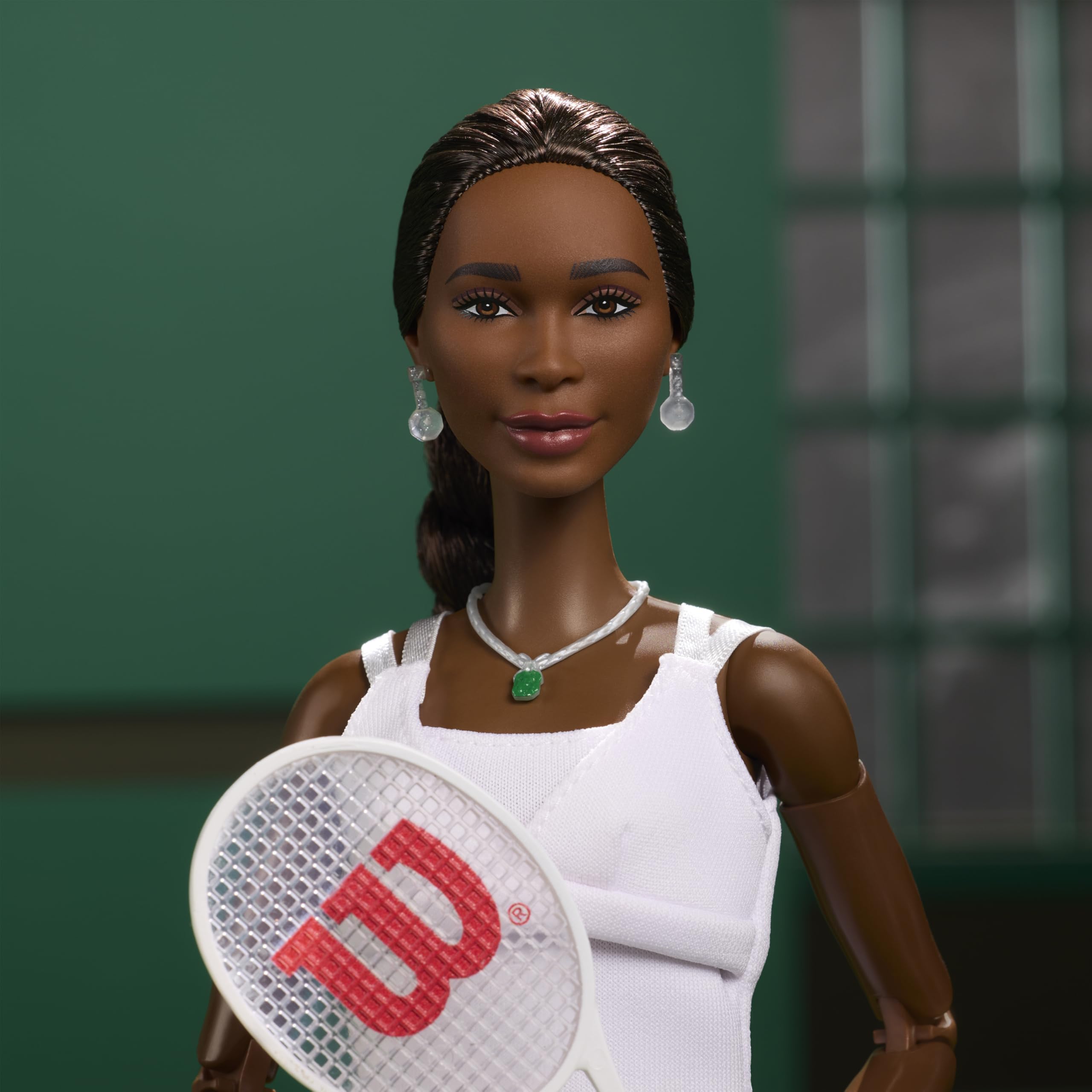 Barbie Venus Williams doll wearing green gem necklace detail.