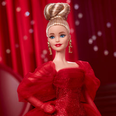 Barbie Signature doll with drop earrings and golden M adds classic charm.