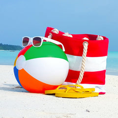 Kids playing with Big Mo's rainbow beach ball at the beach.