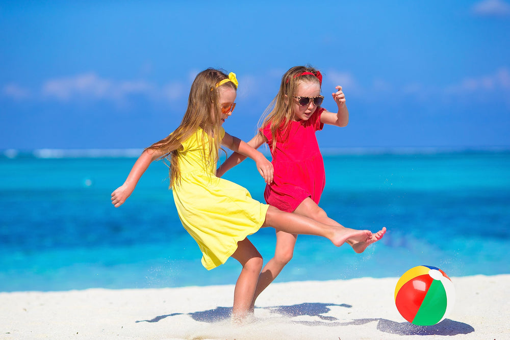Rainbow beach ball on sand for sunny beach day.