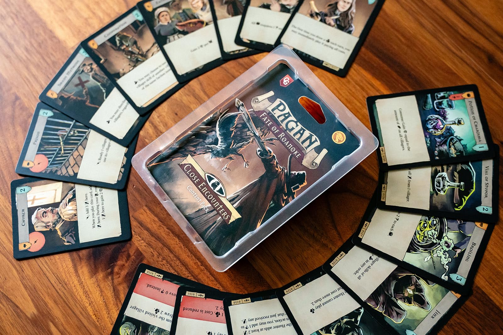 Capstone Games Pagan: Fate of Roanoke card decks highlight witch and hunter dynamics for strategic deduction.