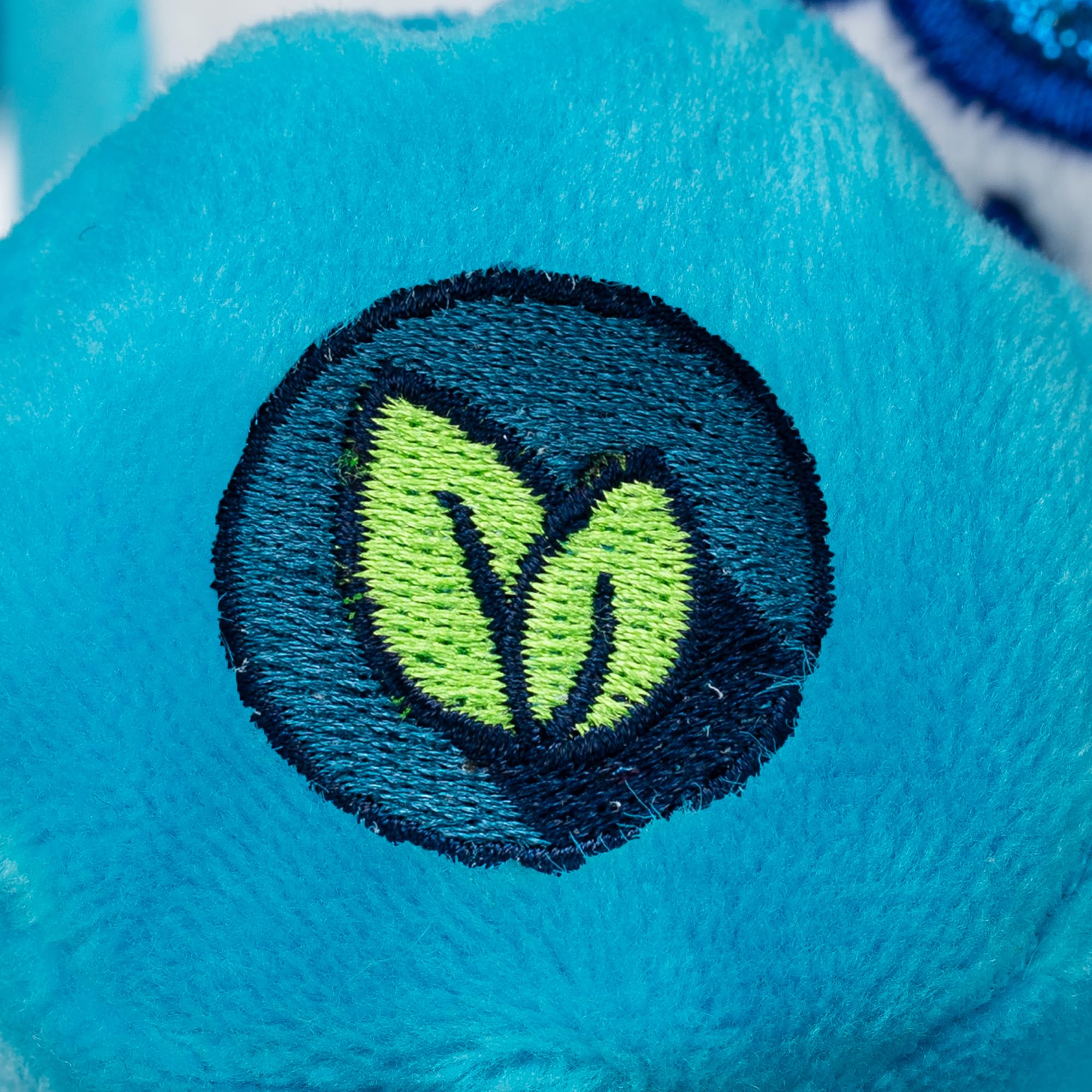 Care Bears Glitter belly badge close-up showing sparkle on Grumpy Bear.