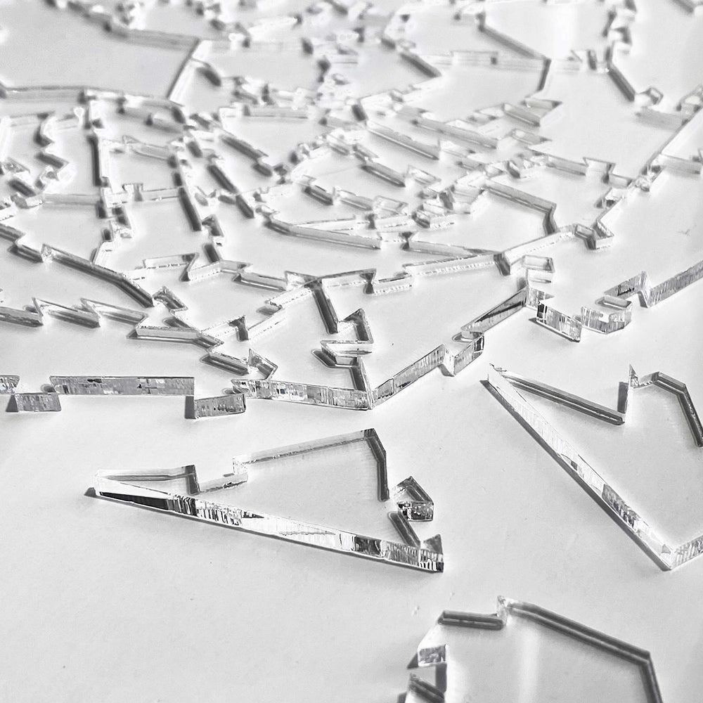 Finished CM Originals Broken Glass Puzzle displays transparent silhouettes against a neutral backdrop.
