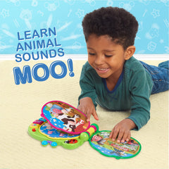 Toddler holding the CoComelon Learning Book during interactive play.