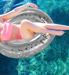 POZA silver confetti pool float in party setup at outdoor pool