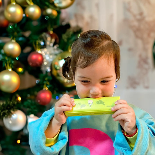 CRAFTEEM Color Blues Harmonica held by a child for beginner-friendly practice