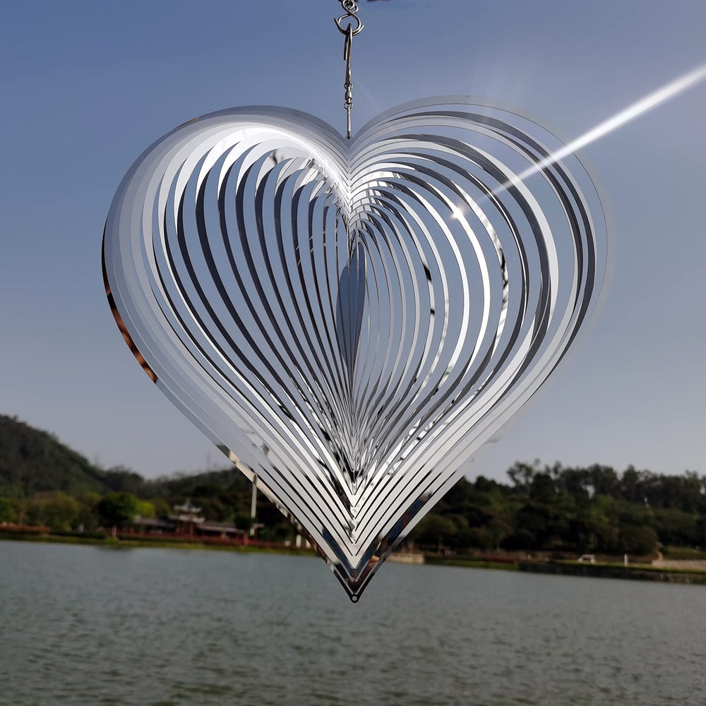 DJUAN stainless steel wind spinner gleams at night with ambient light.