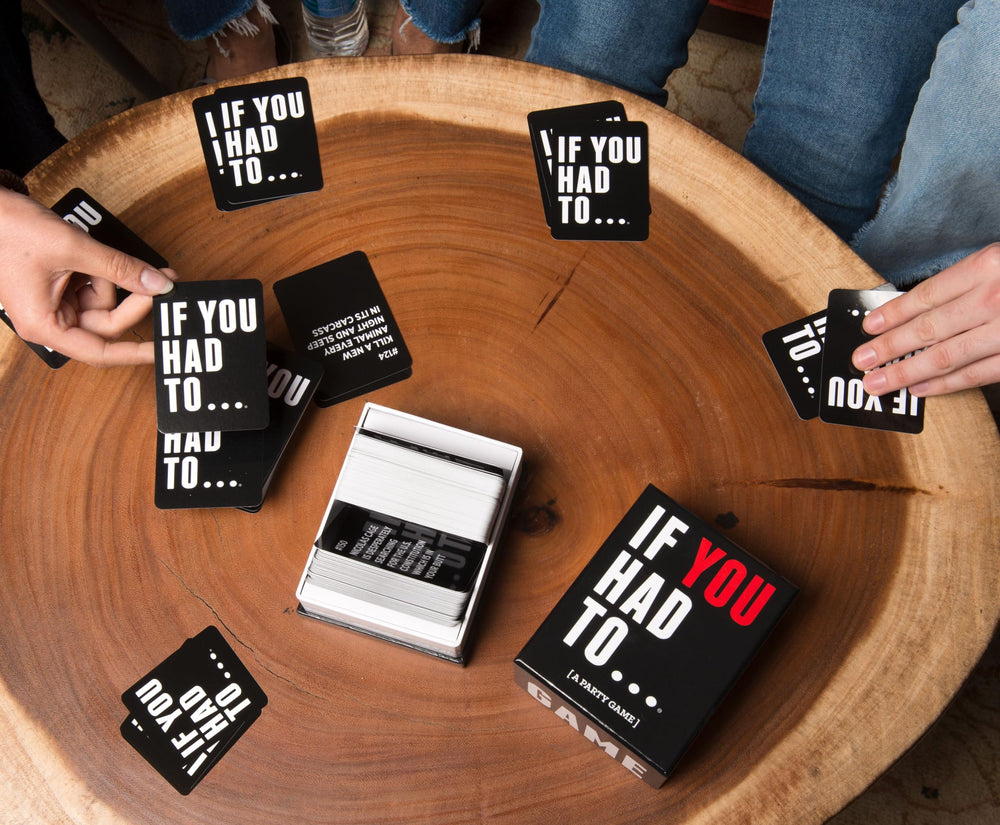 Drunk Stoned or Stupid Would You Rather cards arranged on a party table setup.
