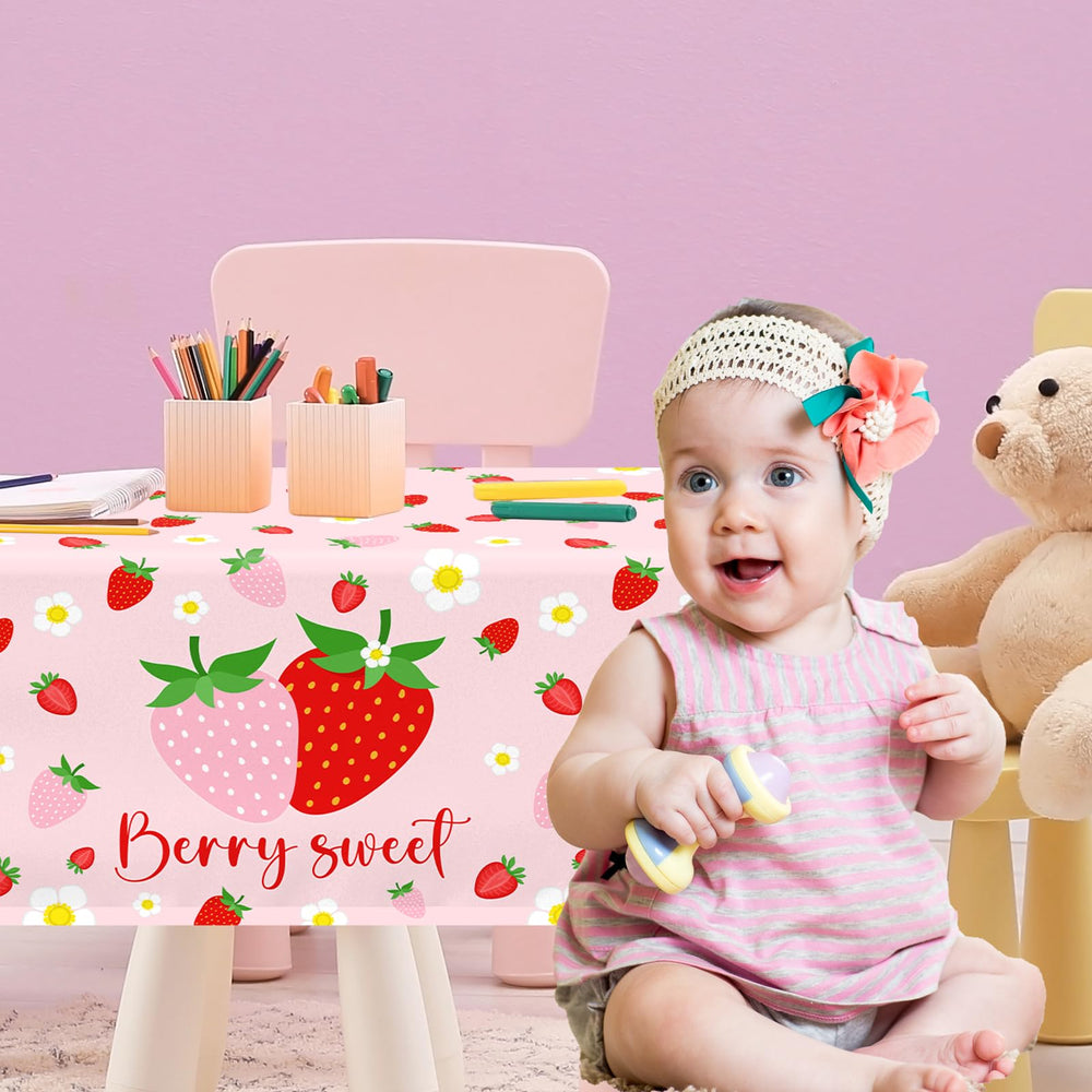 Dydamud strawberry tablecloth with pink background enhances strawberry party decor.