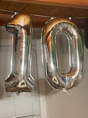 Enyeopd 60th birthday backdrop with silver numeral balloon accent.