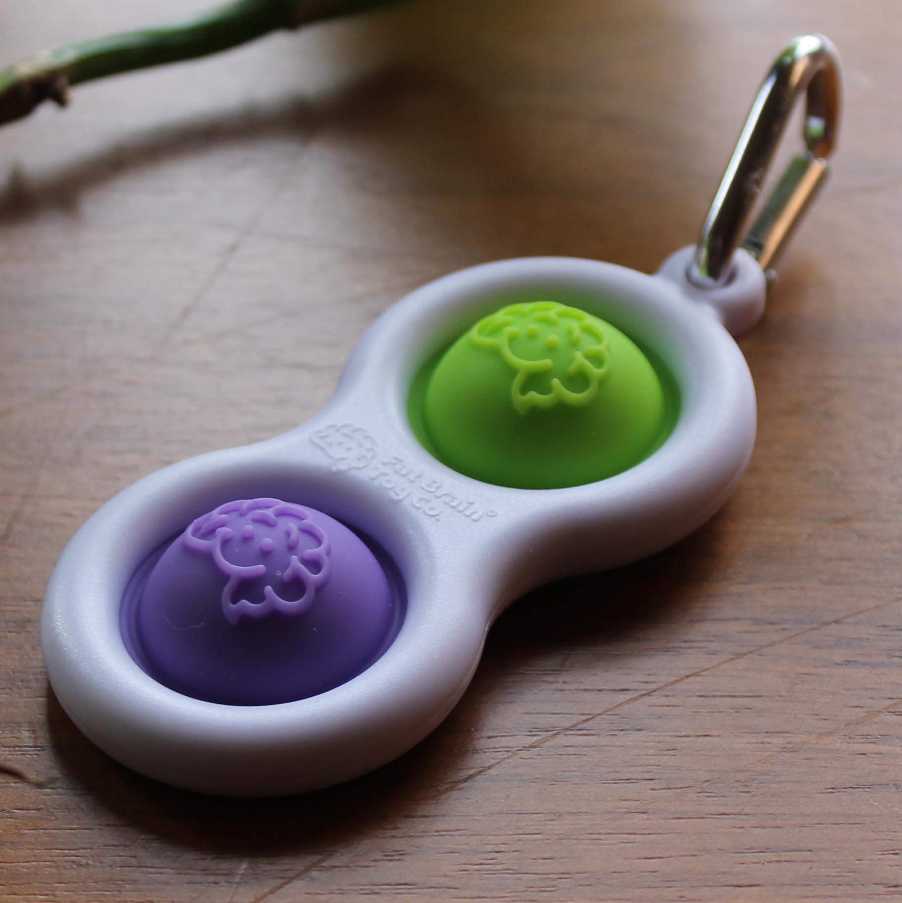 Purple-lime colorway shown on a pocket-sized fidget keychain for portable distraction management.