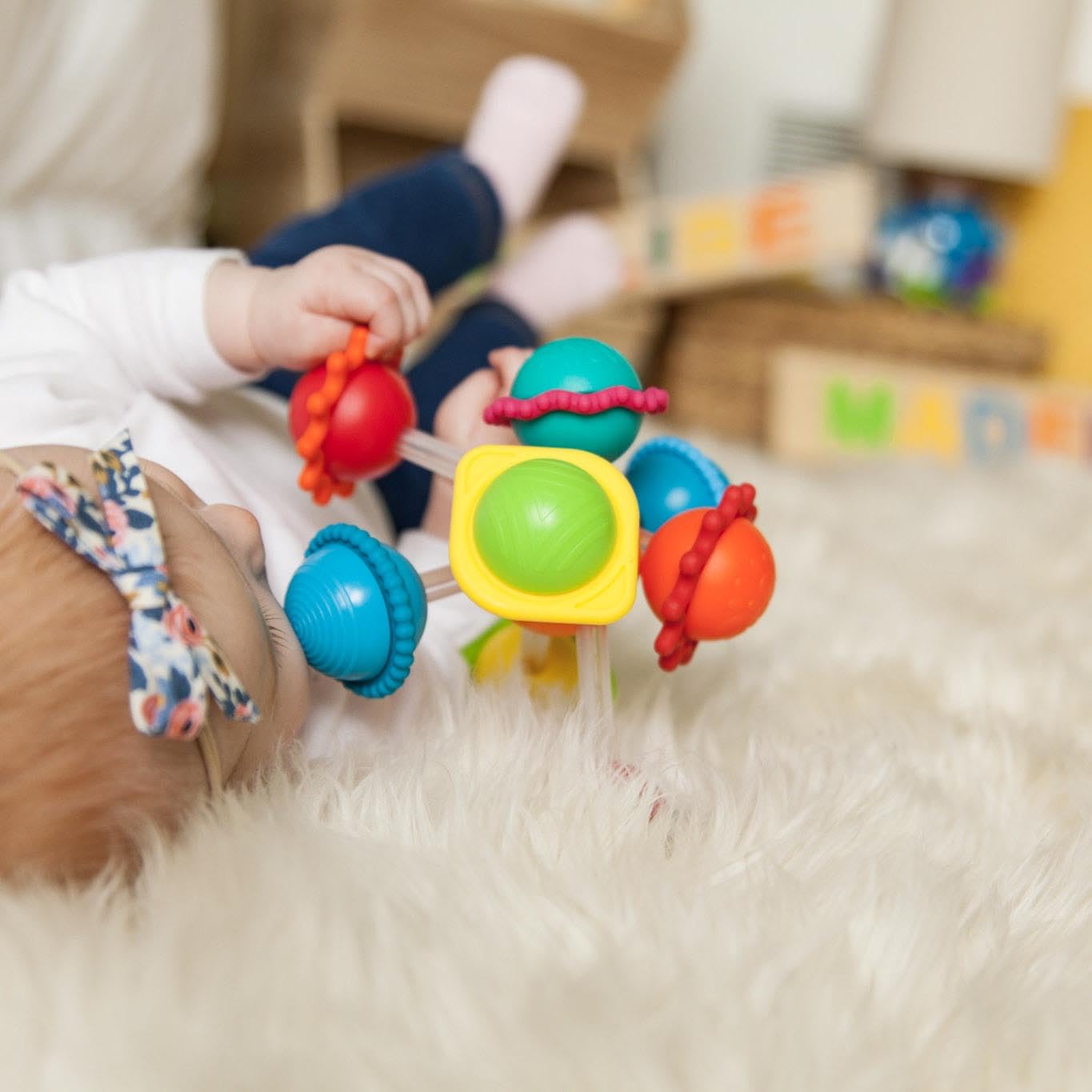 Silicone rings on Wimzle spheres provide safe teething texture.