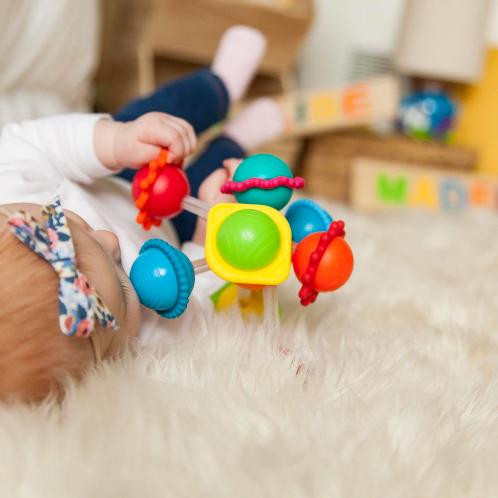 Silicone rings on Wimzle spheres provide safe teething texture.