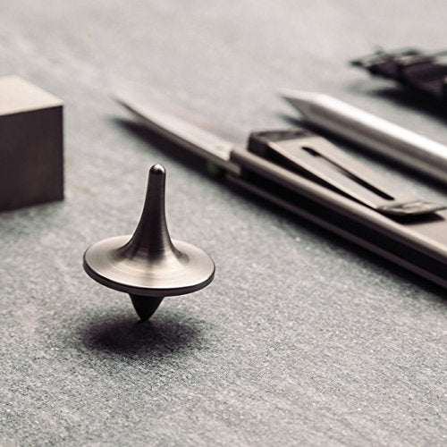ForeverSpin titanium top resting on wood surface showcasing premium craftsmanship
