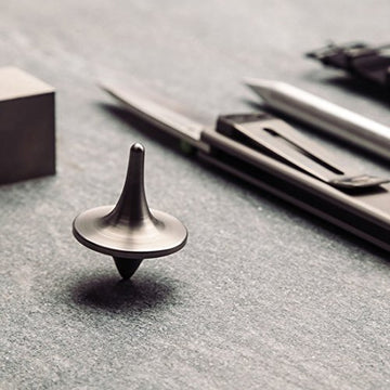 ForeverSpin titanium top resting on wood surface showcasing premium craftsmanship