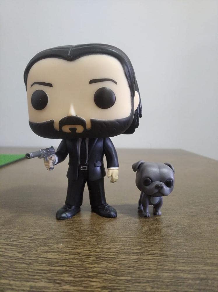 Funko Pop! John Wick figure with dog buddy in dynamic pose complements shelf displays.