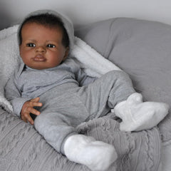 Generic realistic baby doll black boy face close-up showing lifelike eyes for imaginative play.