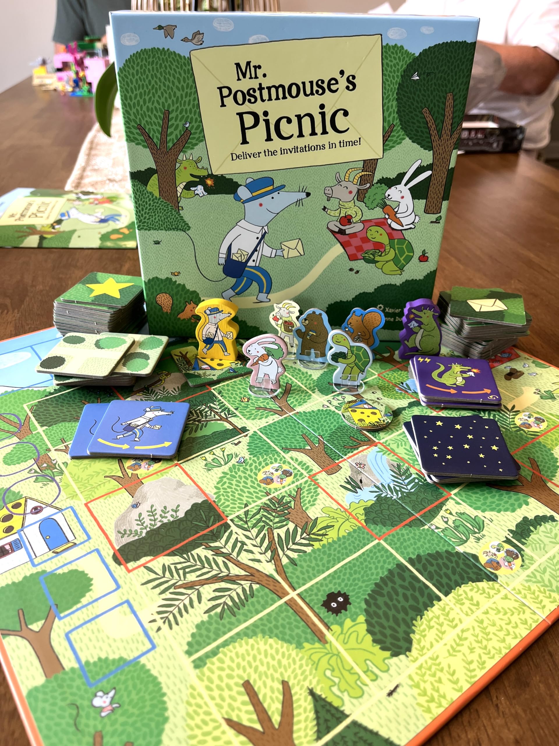 GIGAMIC Mr. Postmouse’s Picnic artwork showcases bright, whimsical village scenes.