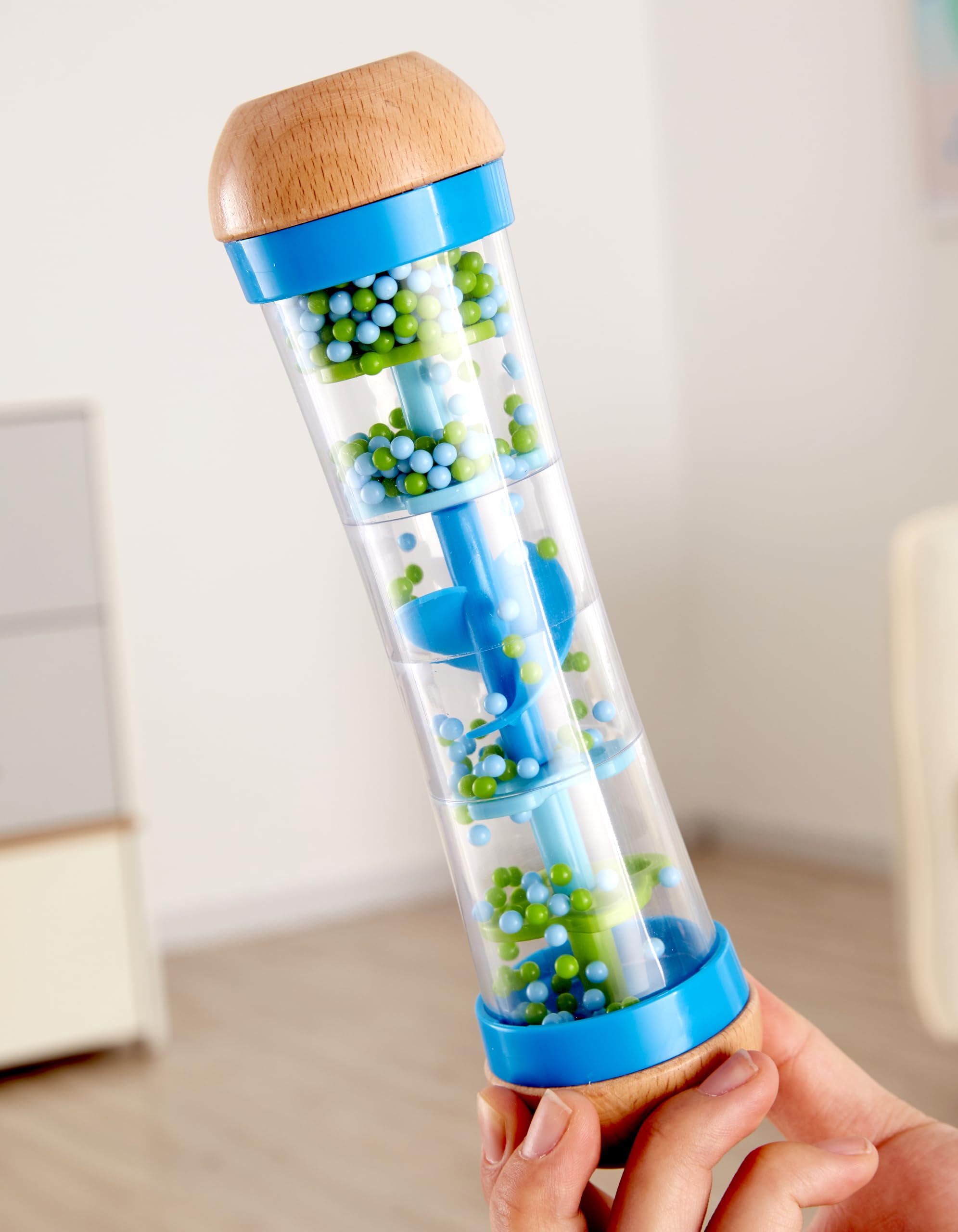 Hape rainmaker blue-green colors captivate children during visual tracking and musical curiosity.