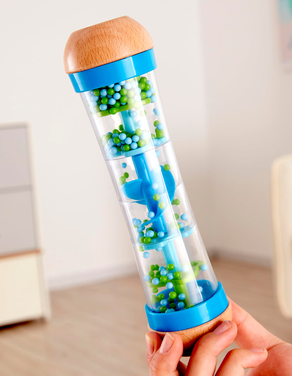 Hape rainmaker blue-green colors captivate children during visual tracking and musical curiosity.