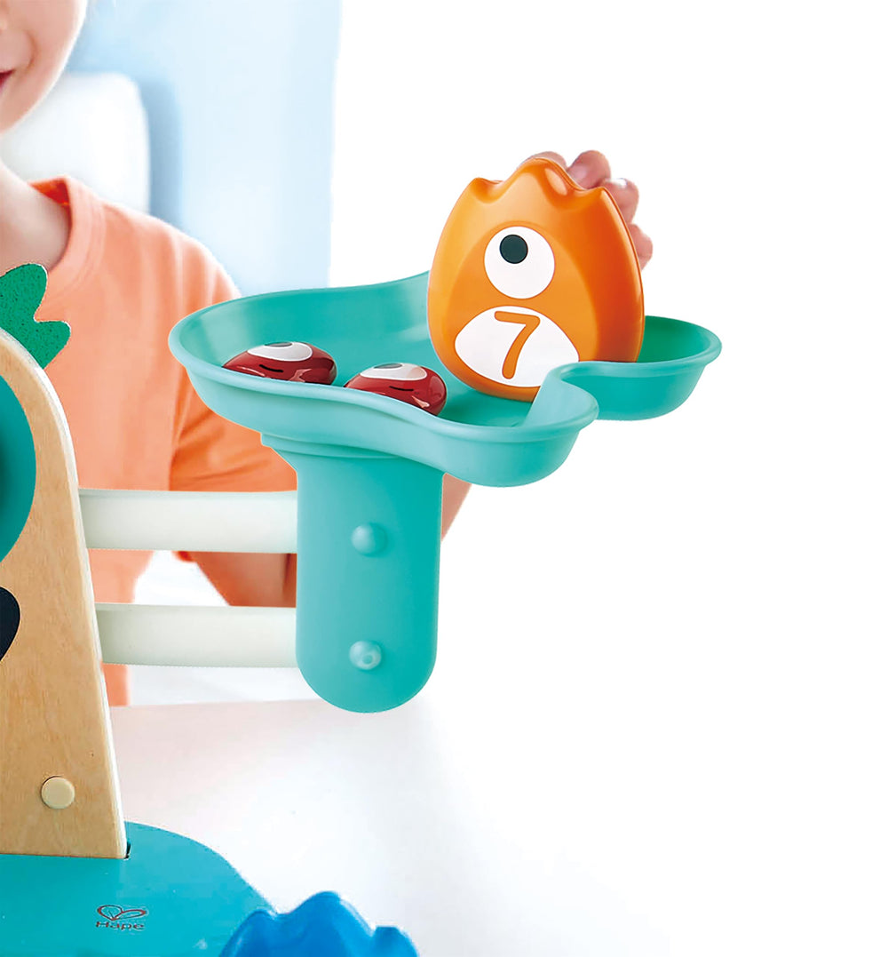 Hape Math Monster Scale used by a child balancing the scale.