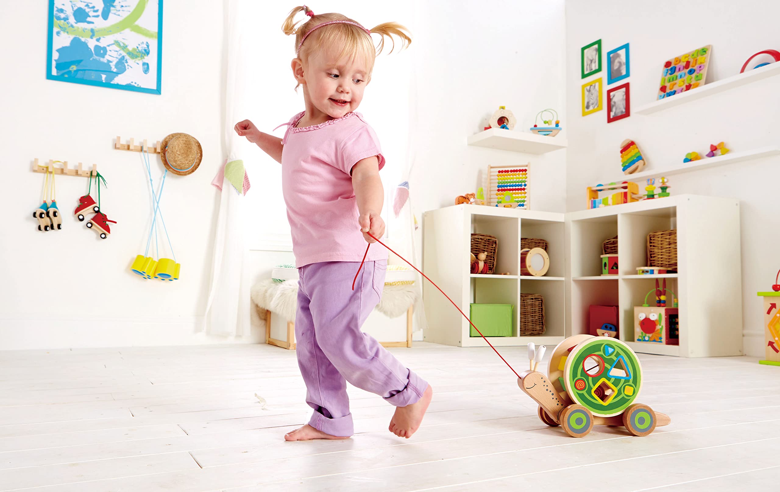Hape Walk-A-Long Snail shell shows triangle, circle, and square holes for sorting practice