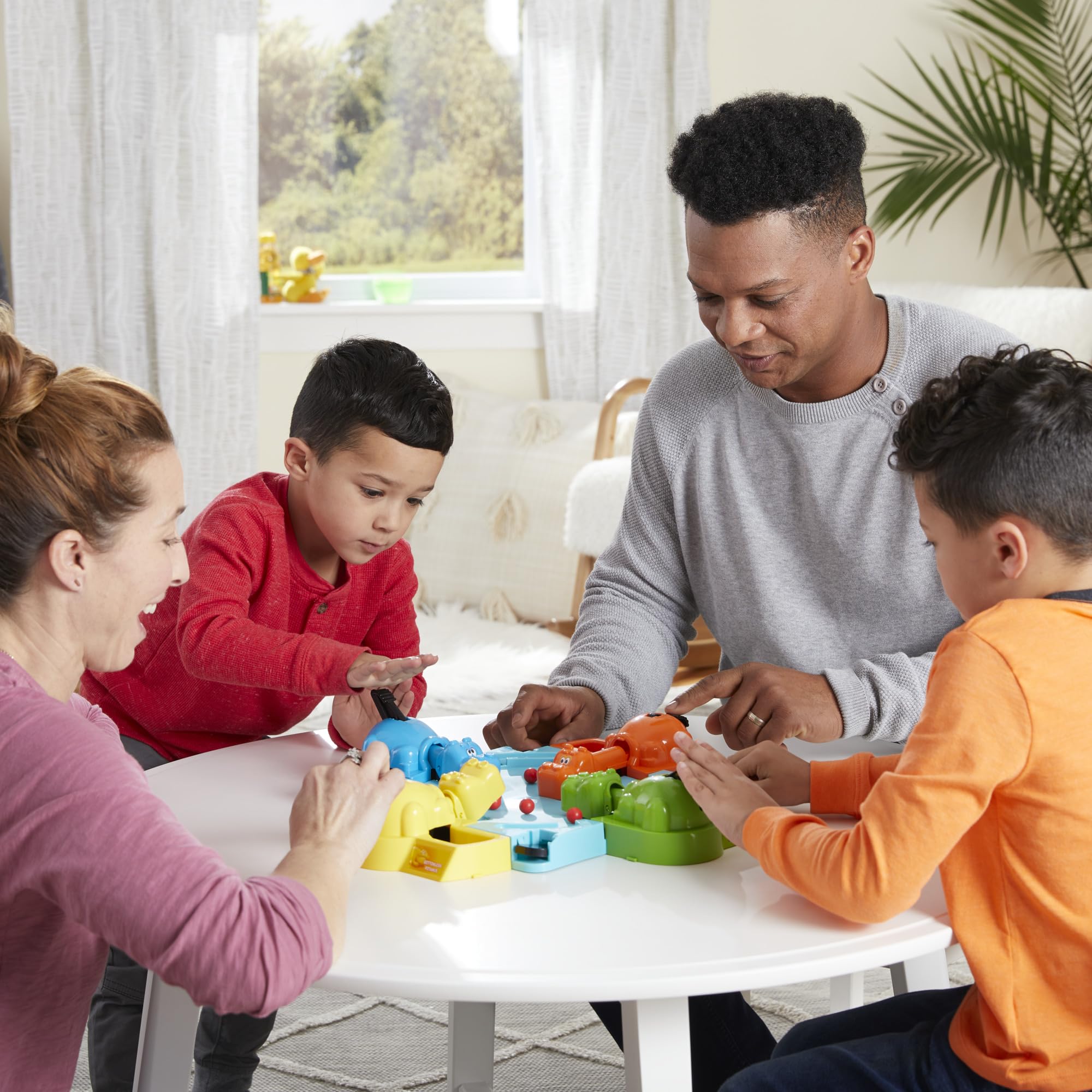 Hasbro Gaming Hungry Hungry Hippos box contents shown with marbles and hippos, easy setup.