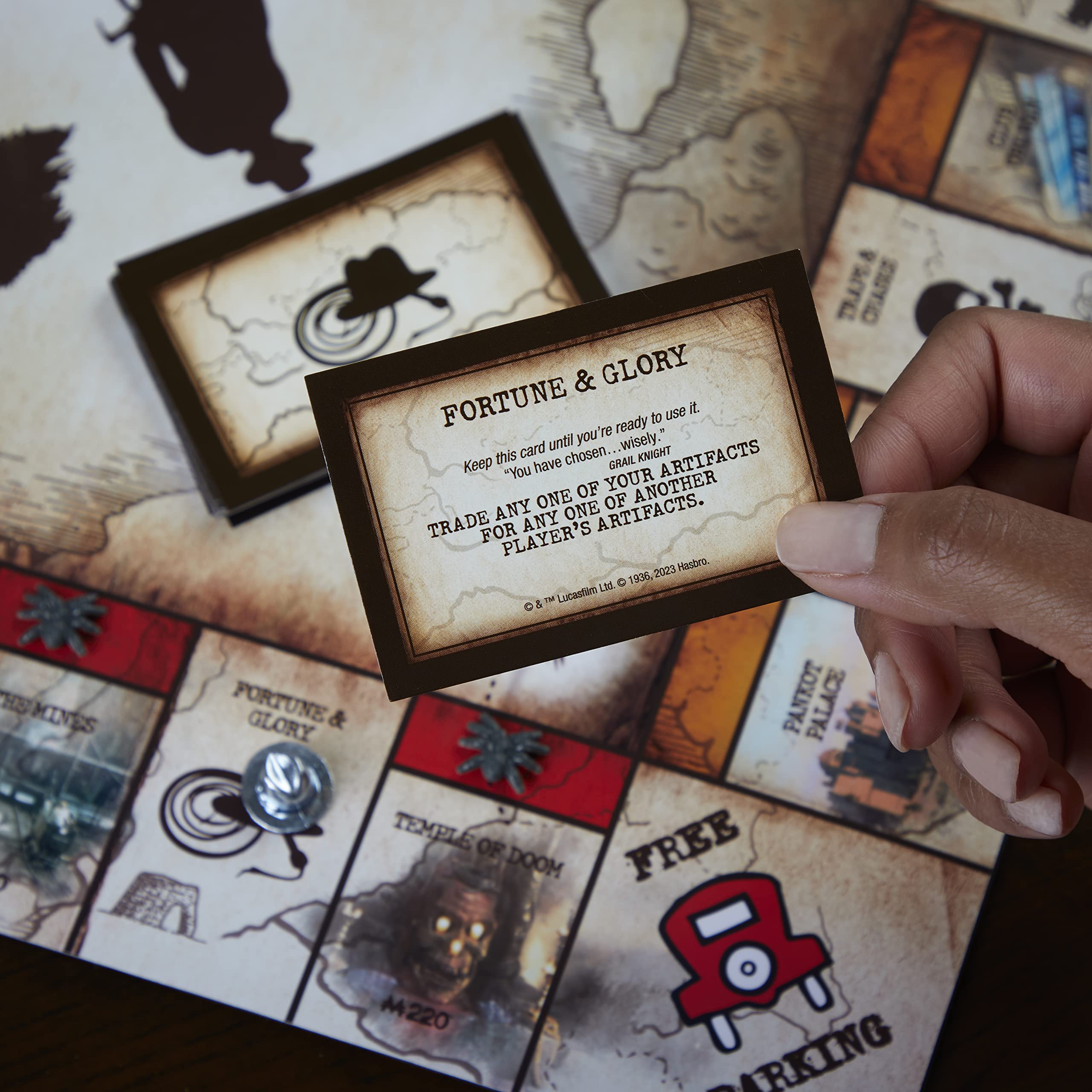 Hasbro Gaming Monopoly Indiana Jones Edition board-artwork evokes classic adventure scenes.