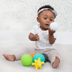 Infantino baby reaching for textured ball to develop hand-eye coordination