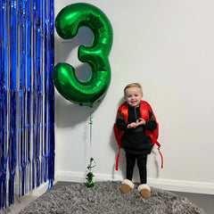 IWERP green 25th birthday balloon arrangement enhances party decor.