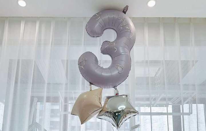 IWERP milestone decor with lilac balloon adds chic celebratory mood.