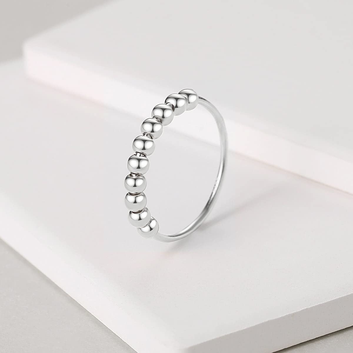 Jacruces fidget ring on hand showing beads spinning for concentration.