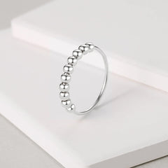 Jacruces fidget ring on hand showing beads spinning for concentration.