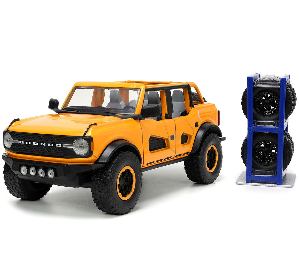 Jada Just Trucks Ford Bronco orange with tire rack for display.