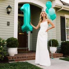 Kelfuoya Teal Number 1 balloon on wall creates elegant backdrop.