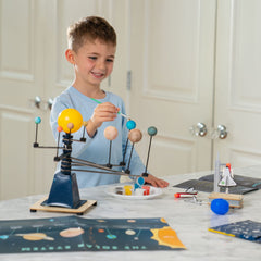 Planet painting with KiwiCo kit boosts fine motor skills and color recognition.