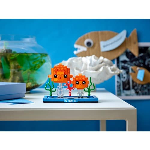 Goldfish and fry figures in a water-themed base with coral accents for display.
