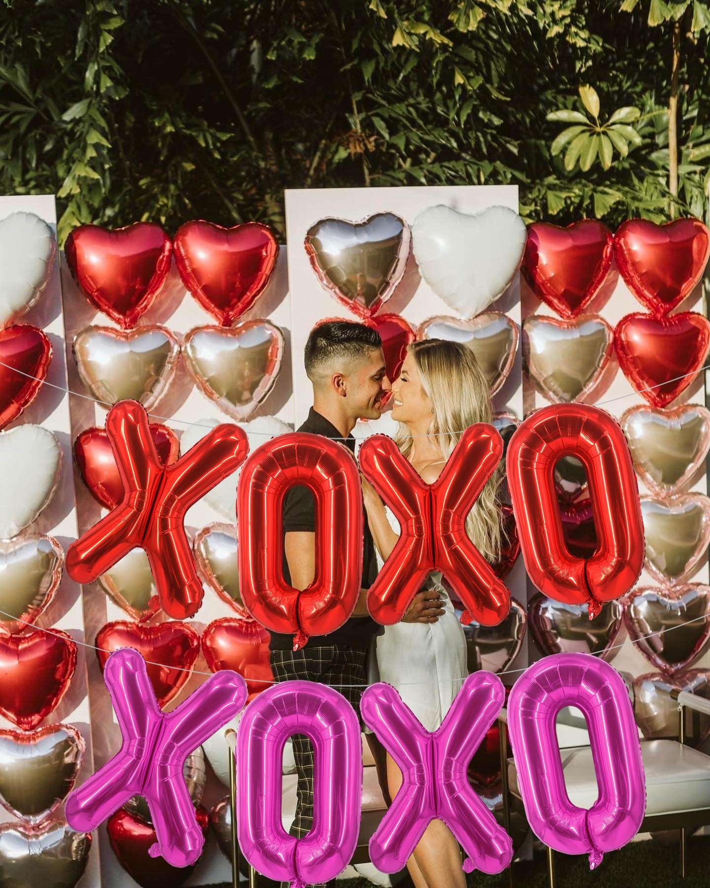 Lovoir arch decor with red and pink XOXO balloons creates a romantic focal point.