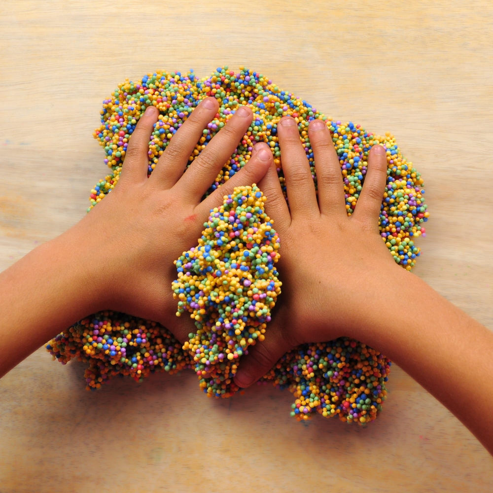 Close-up of LYRK Silly Foam dry texture showing moldable beads for tactile play.